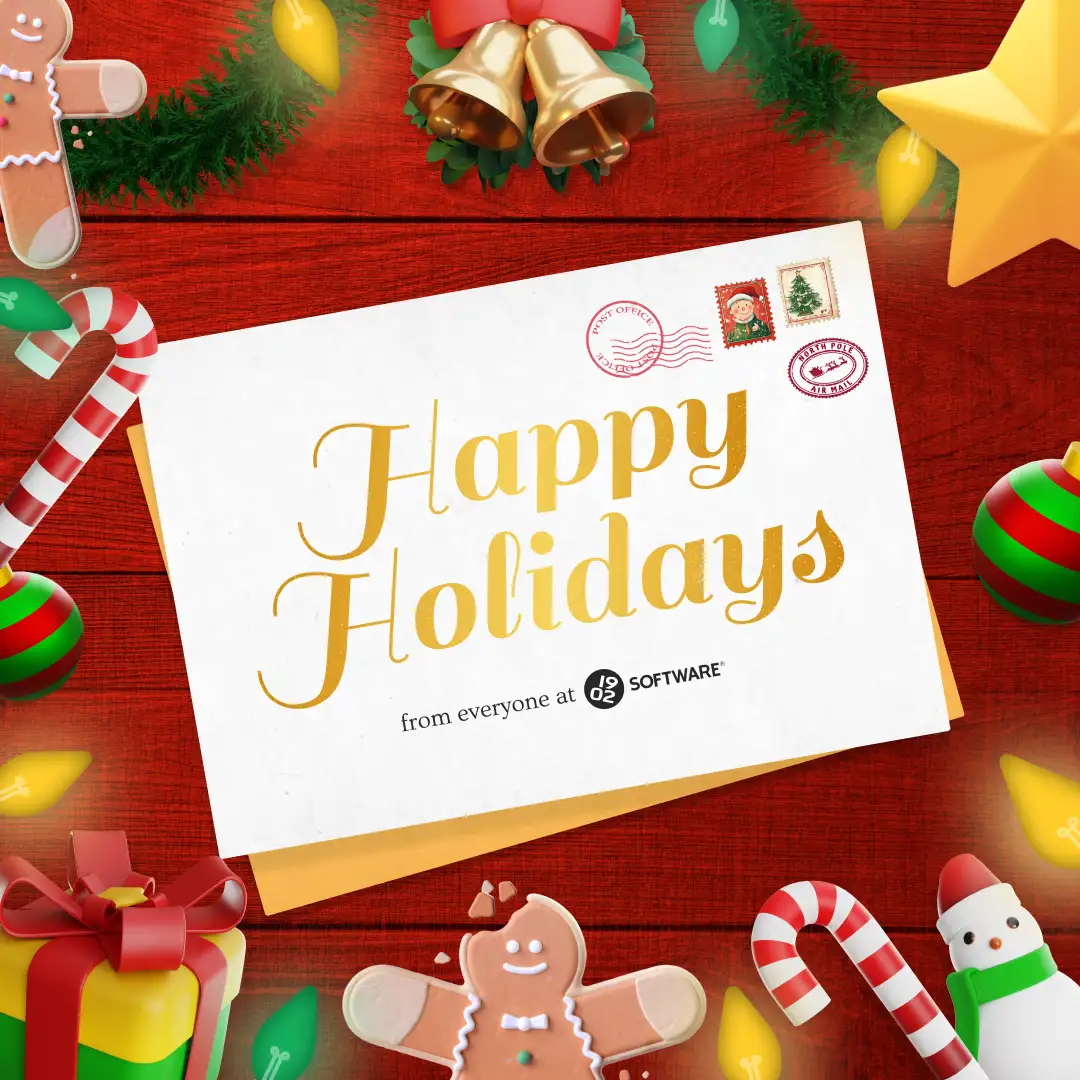 Holiday card on a wooden table with text "Happy Holidays from everyone at 1902 Software" surrounded by Christmas decorations and treats