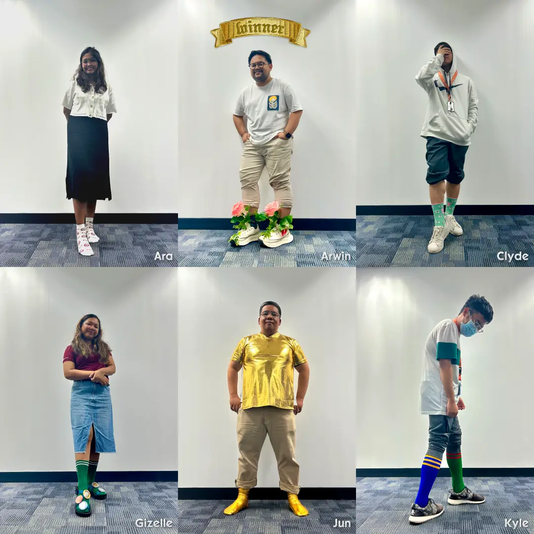 Six team members posing against a white wall with names Ara, Arwin (wearing flower-decorated shoes and a "winner" banner above), Clyde, Gizelle, Jun (wearing gold outfit), and Kyle, each wearing colorful socks.
