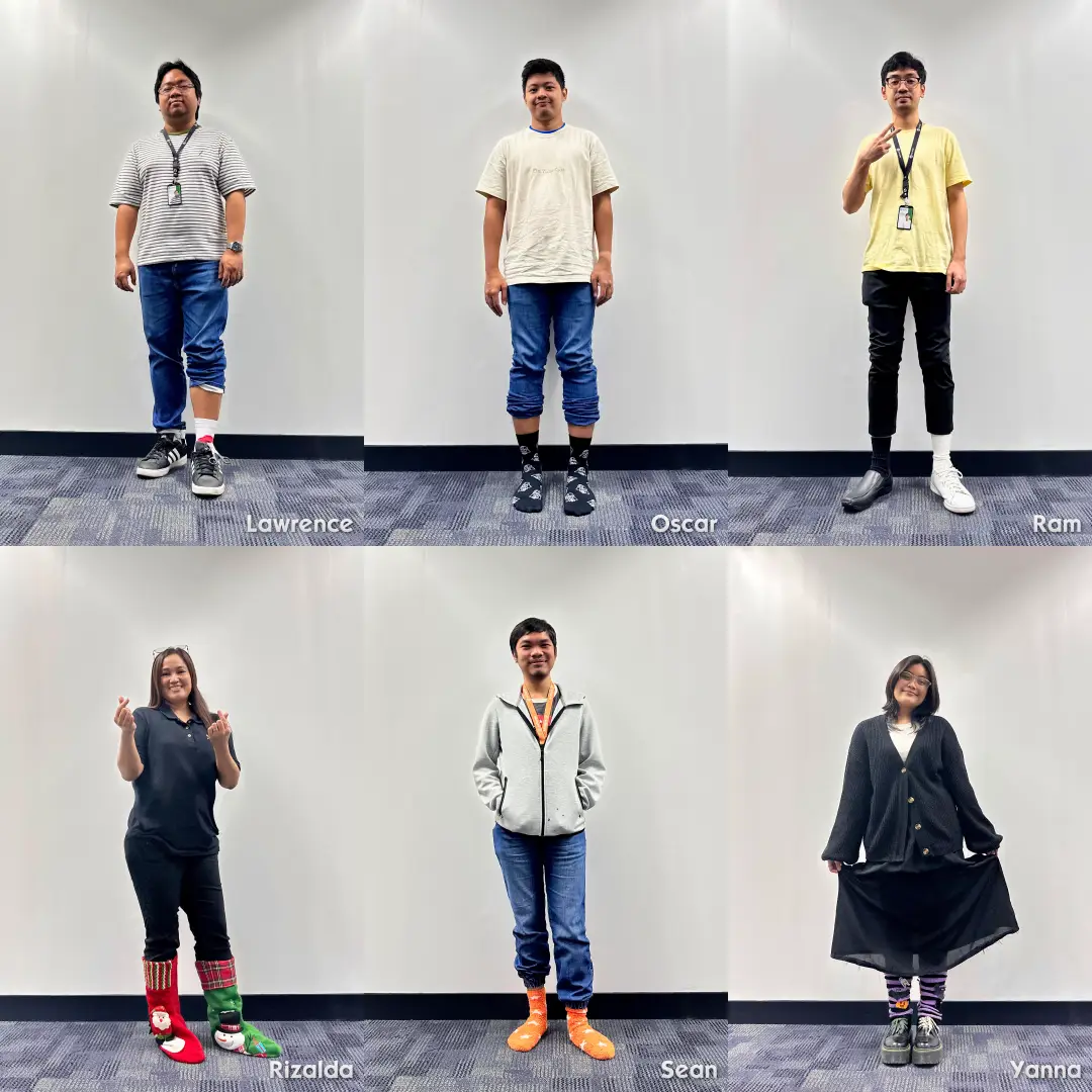 Six team members standing against a white wall, each wearing colorful or mismatched socks, names labeled as Lawrence, Oscar, Ram, Rizalda, Sean, and Yanna.
