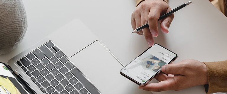 Multi-channel-integration-Intro A person at a desk using a smartphone and a laptop, representing a multi-channel workflow.